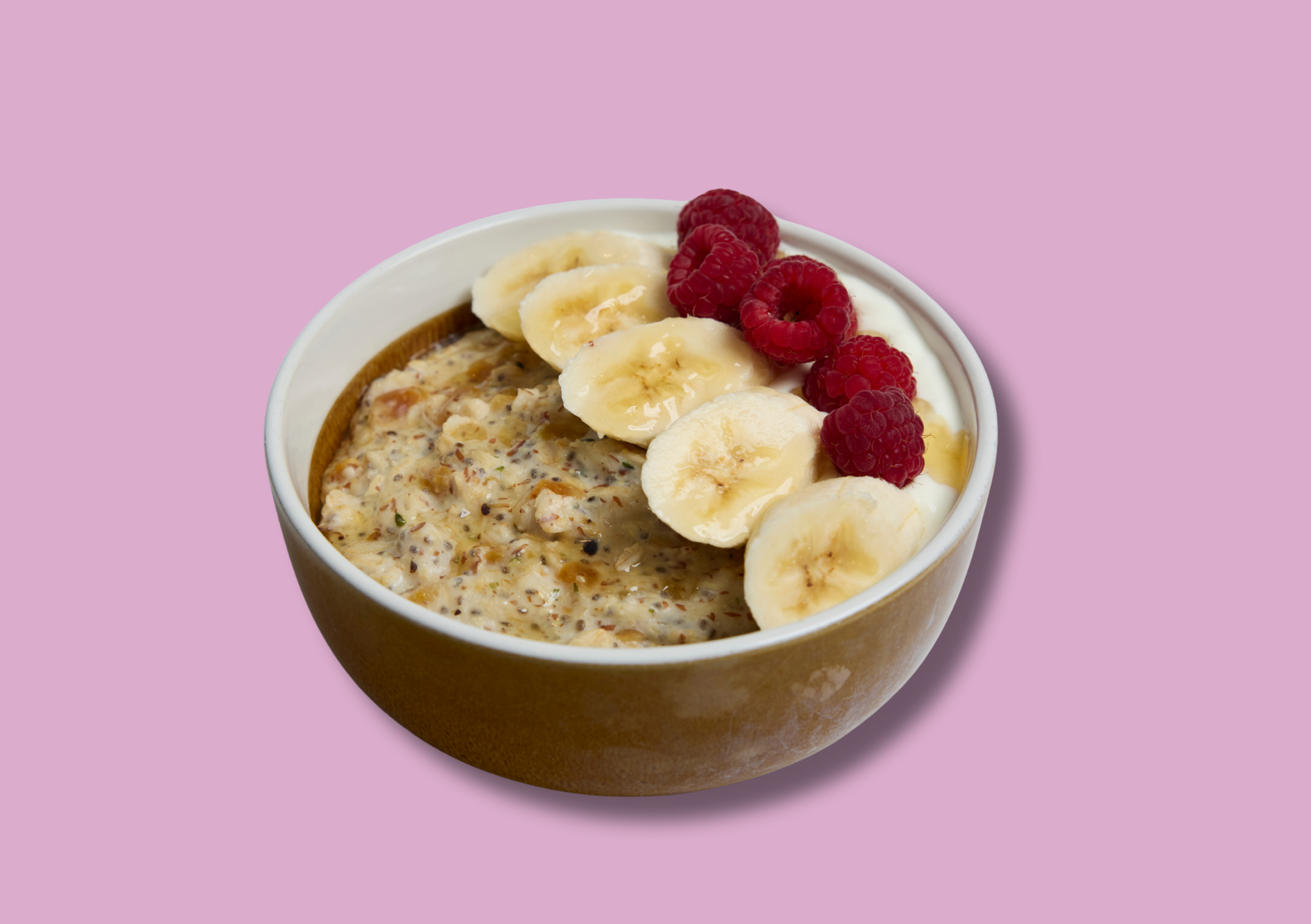 Bowl of collagen-loaded apricot porridge topped with banana, raspberries, and yoghurt. Nourishing postpartum breakfast option.
