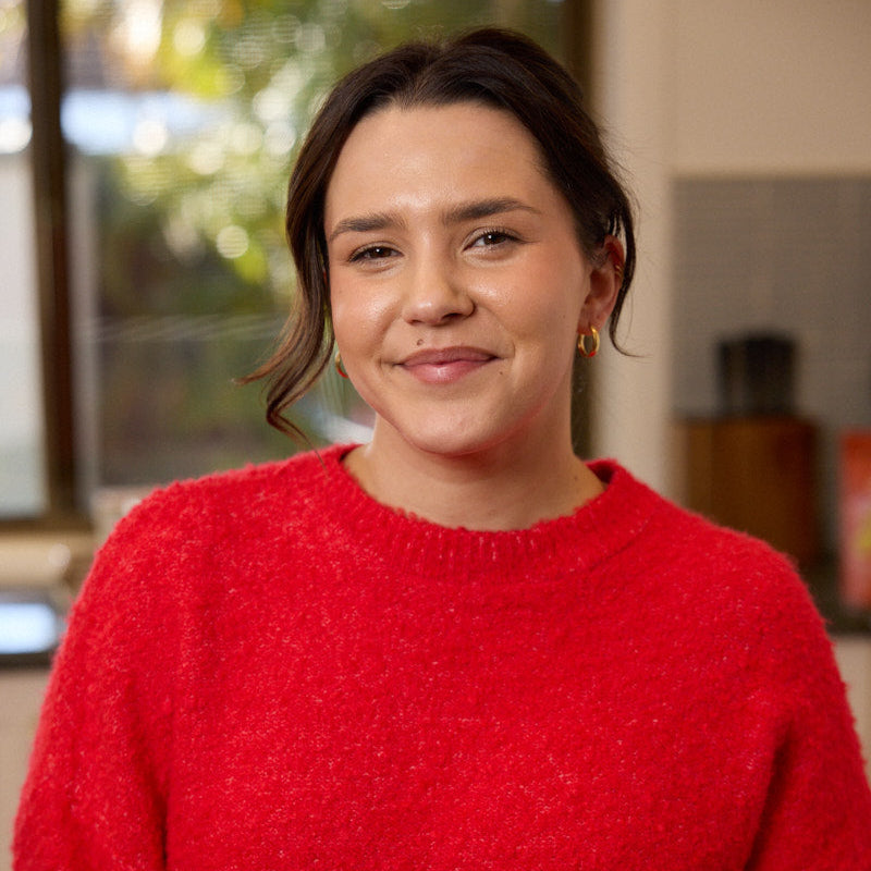 Sophie, founder of Nibbles & Nurture, smiling in a cosy kitchen setting